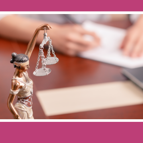 Picture of lady justice statue with a person signing documents in the background