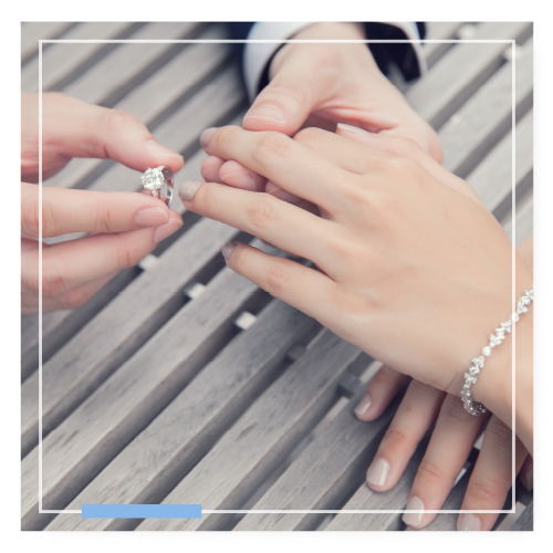 close up of an engagement ring being placed on ring finger