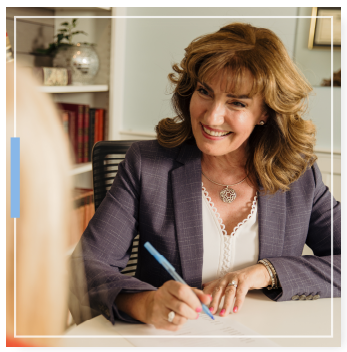 Eileen signing a document with clients